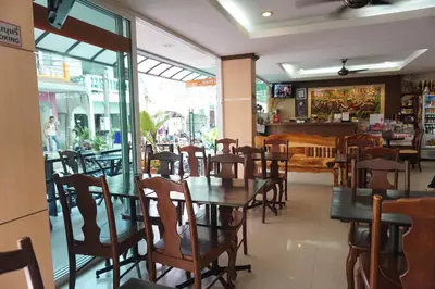 a dining room with tables and chairs in a restaurant at Patong Mansion - SHA Certified in Patong Beach