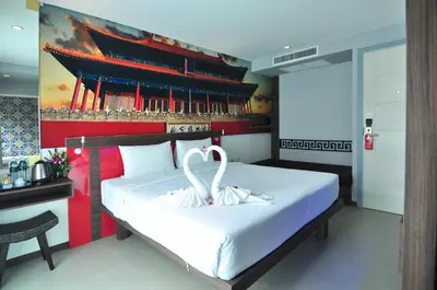 a bedroom with a bed with two swans on it at The AIM Patong Hotel in Patong Beach