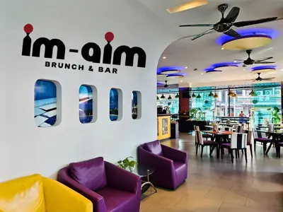 a restaurant with purple chairs and a sign that reads mum brunch and bar at The AIM Patong Hotel in Patong Beach