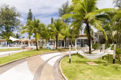 a hammock in a park with palm trees at Arinara Beach Resort Phuket - SHA Extra Plus in Bang Tao Beach