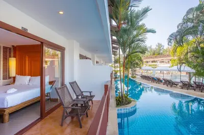 a hotel room with a bed and a swimming pool at Arinara Beach Resort Phuket - SHA Extra Plus in Bang Tao Beach
