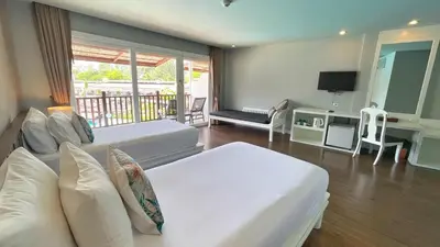 a hotel room with two beds and a balcony at Arinara Beach Resort Phuket - SHA Extra Plus in Bang Tao Beach