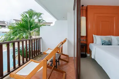 a room with a bedroom and a bed and a balcony at Arinara Beach Resort Phuket - SHA Extra Plus in Bang Tao Beach