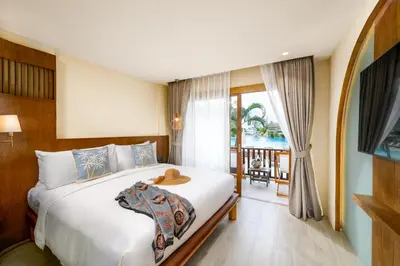 a bedroom with a large bed and a balcony at Arinara Beach Resort Phuket - SHA Extra Plus in Bang Tao Beach