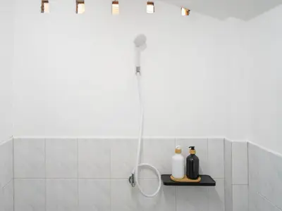 a shower with a shower head in a bathroom at Sand Beach Bungalow in Klong Muang Beach