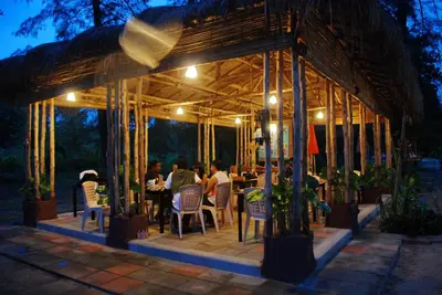 a group of people sitting at a restaurant at night at Sand Beach Bungalow in Klong Muang Beach