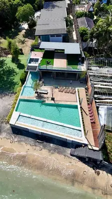 an overhead view of a swimming pool next to the ocean at Charcoal Panwa Beach Phuket in Ban Tha Khreng