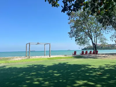 a park with a tree and a swing set on the beach at Charcoal Panwa Beach Phuket in Ban Tha Khreng
