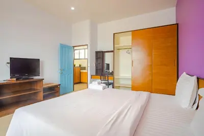 a bedroom with a white bed and a flat screen tv at AJ Residence in Phuket Town
