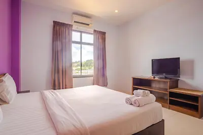 a hotel room with two beds and a television at AJ Residence in Phuket Town