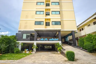 a tall tan building with a driveway in front of it at AJ Residence in Phuket Town