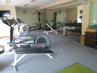 a gym with treadmills and machines in a room at Kata Beach Aspasia Boutique Apartment in Kata Beach