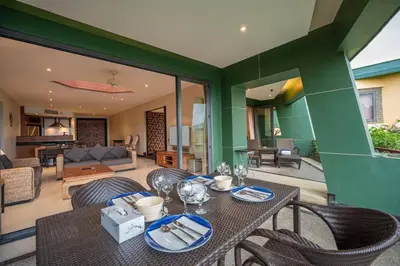 a dining table and chairs in a living room at Kata Beach Aspasia Boutique Apartment in Kata Beach