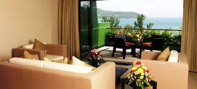 a living room with two couches and a balcony with a table at Kata Beach Aspasia Boutique Apartment in Kata Beach