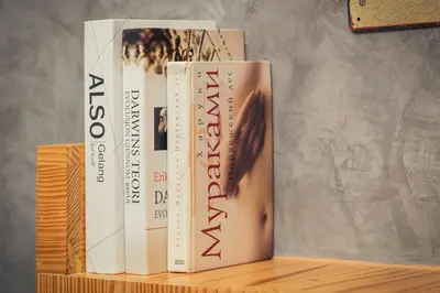four books stacked on top of a wooden shelf at Cozy design studio near Nai Harn beach in Nai Harn Beach
