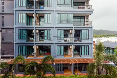an apartment building with balconies and palm trees at Cozy design studio near Nai Harn beach in Nai Harn Beach
