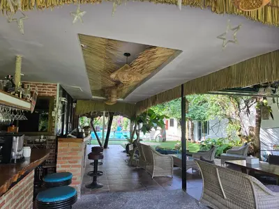 a restaurant with a patio with chairs and a bar at OASIS Phuket Airport in Nai Yang Beach