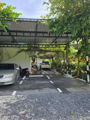 a parking lot with two cars parked in it at OASIS Phuket Airport in Nai Yang Beach