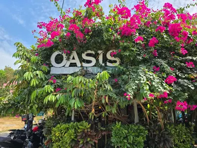 a sign covered in pink flowers and plants at OASIS Phuket Airport in Nai Yang Beach