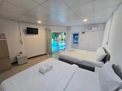 a hospital room with two beds and a television at OASIS Phuket Airport in Nai Yang Beach