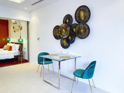 a dining room with chairs and a table and plates on the wall at Beautiful 1br Plunge Pool Villa Walk To Bangtao Beach in Ban Thalat Choeng Thale