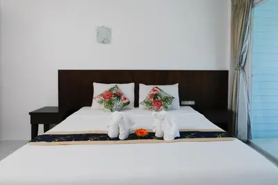 a bed with two vases with flowers on it at Kiwi Boutique Hotel in Patong Beach