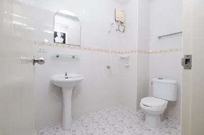 a white bathroom with a toilet and a sink at Kiwi Boutique Hotel in Patong Beach