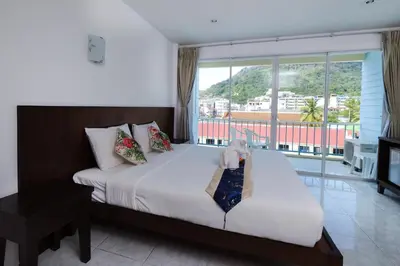 a bedroom with a white bed with a window at Kiwi Boutique Hotel in Patong Beach