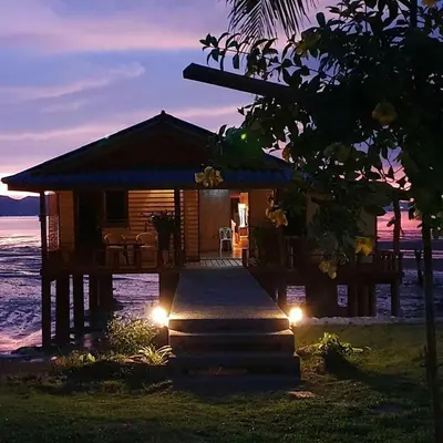 a cabin on the beach at night with lights at Lam Sai village hotel Koh Yao Noi in Ko Yao Noi