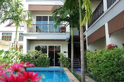 a house with a swimming pool in front of a building at Vivi Boutique Room Hotel SHA Plus in Rawai Beach