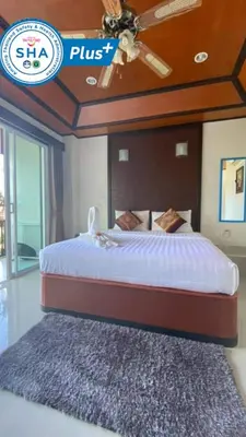 a bedroom with a bed with a ceiling fan and a rug at Vivi Boutique Room Hotel SHA Plus in Rawai Beach
