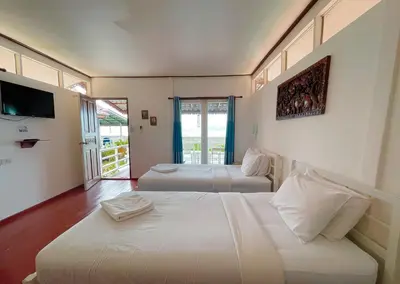 a hotel room with two beds and a television at Holiday Resort - SHA Plus in Ko Yao Noi