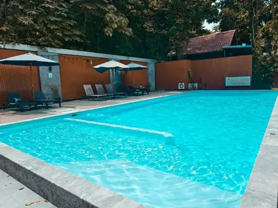 a large blue swimming pool with chairs and umbrellas at Holiday Resort - SHA Plus in Ko Yao Noi