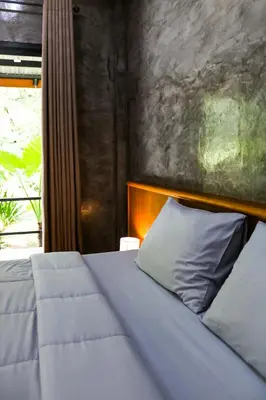a bedroom with a white bed and a window at Annie Meen's place Koh Yao Noi in Ko Yao Noi