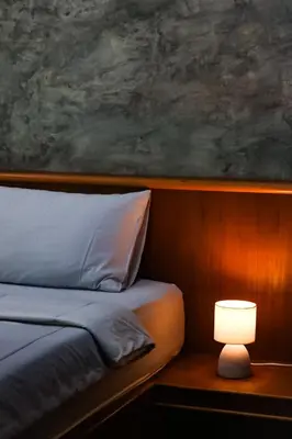 a bedroom with a bed and a table with a lamp at Annie Meen's place Koh Yao Noi in Ko Yao Noi