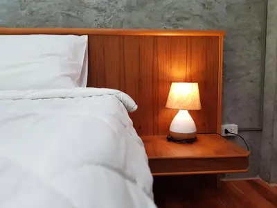 a bedroom with a bed with a lamp on a table at Annie Meen's place Koh Yao Noi in Ko Yao Noi