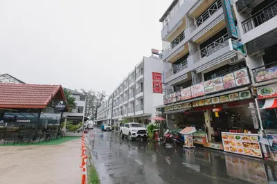 a city street in the rain with a building at Royal Beach Residence, Patong Beach in Patong Beach