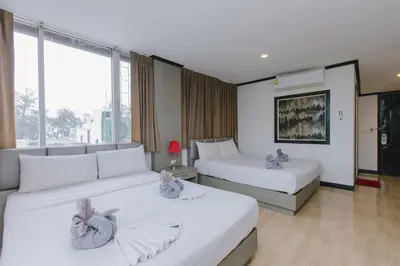 a hotel room with two beds and a large window at Royal Beach Residence, Patong Beach in Patong Beach