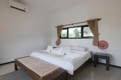 a bedroom with a bed and a window at Foxtail Palm Villa in Rawai Beach