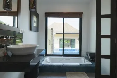 a bathroom with a tub and a large window at Foxtail Palm Villa in Rawai Beach