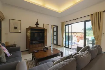 a living room with two couches and a tv at Foxtail Palm Villa in Rawai Beach