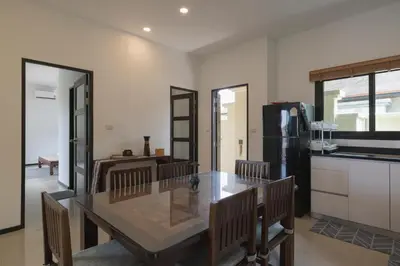 a kitchen and dining room with a table and chairs at Foxtail Palm Villa in Rawai Beach
