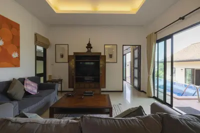 a living room with a couch and a tv at Foxtail Palm Villa in Rawai Beach