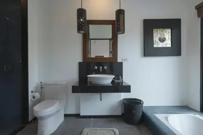a bathroom with a sink and a toilet and a mirror at Foxtail Palm Villa in Rawai Beach