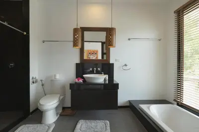 a bathroom with a sink and a toilet and a tub at Cocktail Palm Villa in Rawai Beach