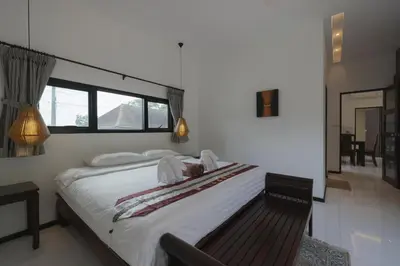 a bedroom with a large white bed and a mirror at Cocktail Palm Villa in Rawai Beach