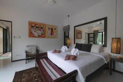 a bedroom with two beds and a large mirror at Cocktail Palm Villa in Rawai Beach