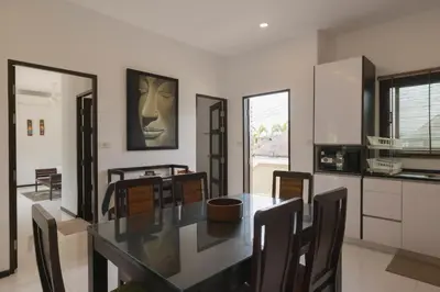 a kitchen and dining room with a table and chairs at Cocktail Palm Villa in Rawai Beach