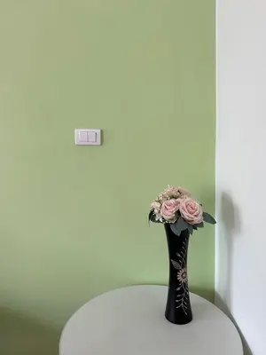 a vase filled with pink roses sitting on a table at นิวเวฟภูเก็ต in Ban Na Kok