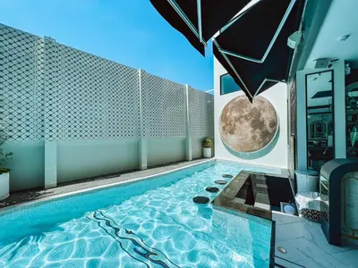 a swimming pool with a moon mural on the wall at Ratri Hotel Phuket Old Town in Phuket Town